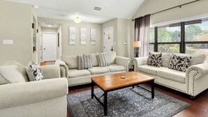 Ein Wohnzimmer mit zwei Sofas, einem Couchtisch und einem Deckenventilator.