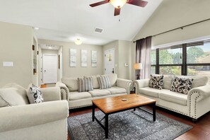 A living room with two sofas, a coffee table, and a ceiling fan. - Charming cottage near Tubing, Whitewater, Boat Ramps and more!!!! (Canyon Lake)