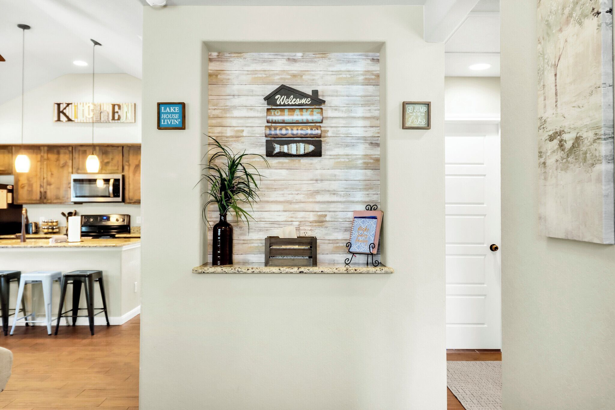 A reception area with a rustic wooden wall, a welcome sign, a fish decoration, and a bench.