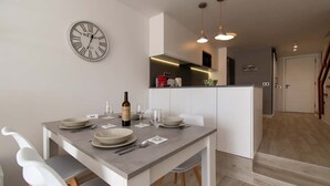 Eine moderne Küche mit weißen Schränken, einem eingebauten Backofen und einer Pendelleuchte.