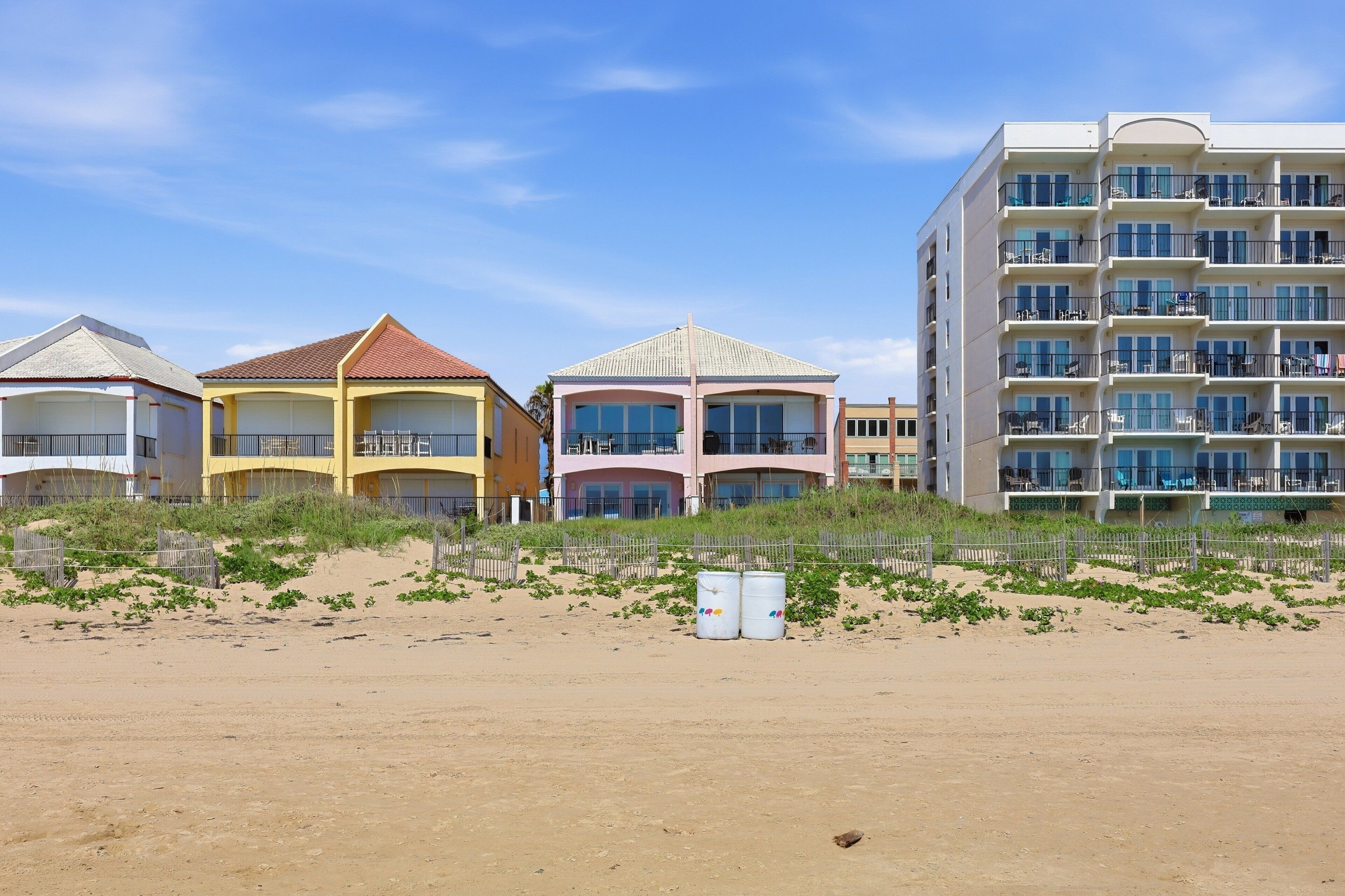A beachfront hotel with multiple buildings, including a large multi-story structure with balconies.