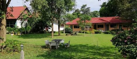 Un patio con césped, mobiliario exterior y edificios con tejados rojos.