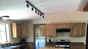 A kitchen with wooden cabinets, a central island, a stove, and a dishwasher. - Redcloud Getaway - Great Property Along the Lake Fork of the Gunnison with Direct Access to Trails (Lake City)