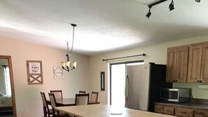 A spacious kitchen with a large island, wooden cabinets, and a modern refrigerator. - Redcloud Getaway - Great Property Along the Lake Fork of the Gunnison with Direct Access to Trails (Lake City)