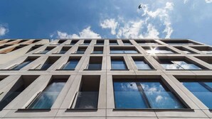 Een modern gebouw met een raamrooster en een heldere lucht.