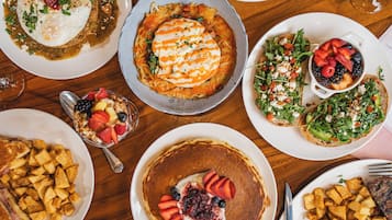 A variety of breakfast dishes including pancakes, omelets, and fruit salads.