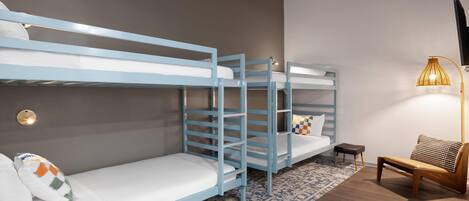 A bunk bed room with a small table and a lamp.