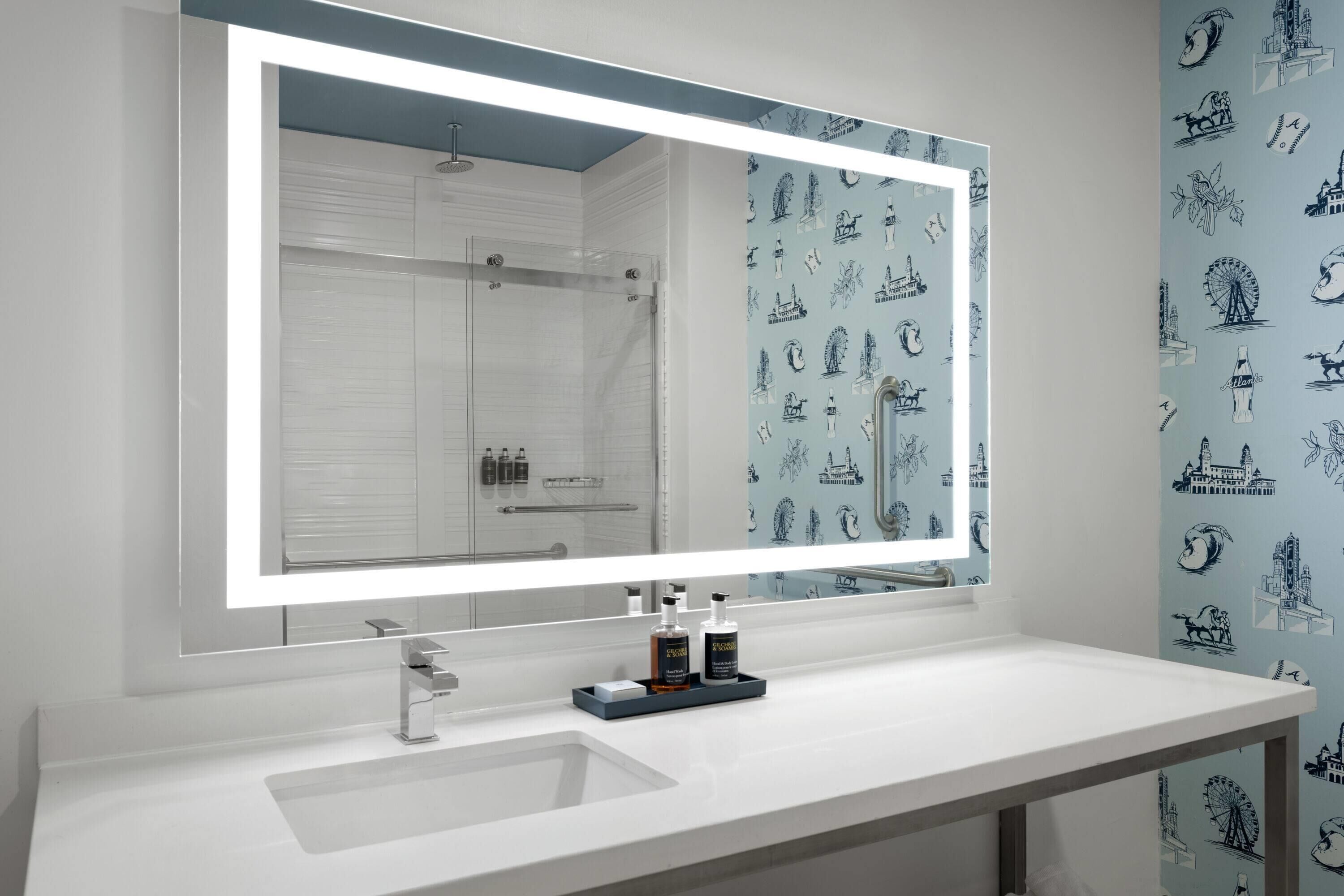Un bagno con uno specchio grande, un lavandino bianco e una doccia.