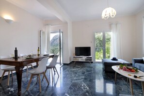Relax in style with a comfortable sofa, dining table, and flat-screen TV, perfect for unwinding and enjoying the views.