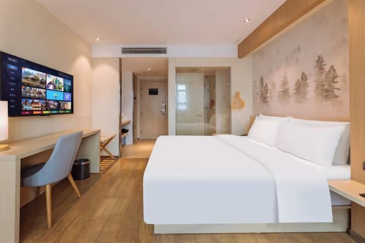 Minibar, escritorio, cortinas blackout y tabla de planchar con plancha