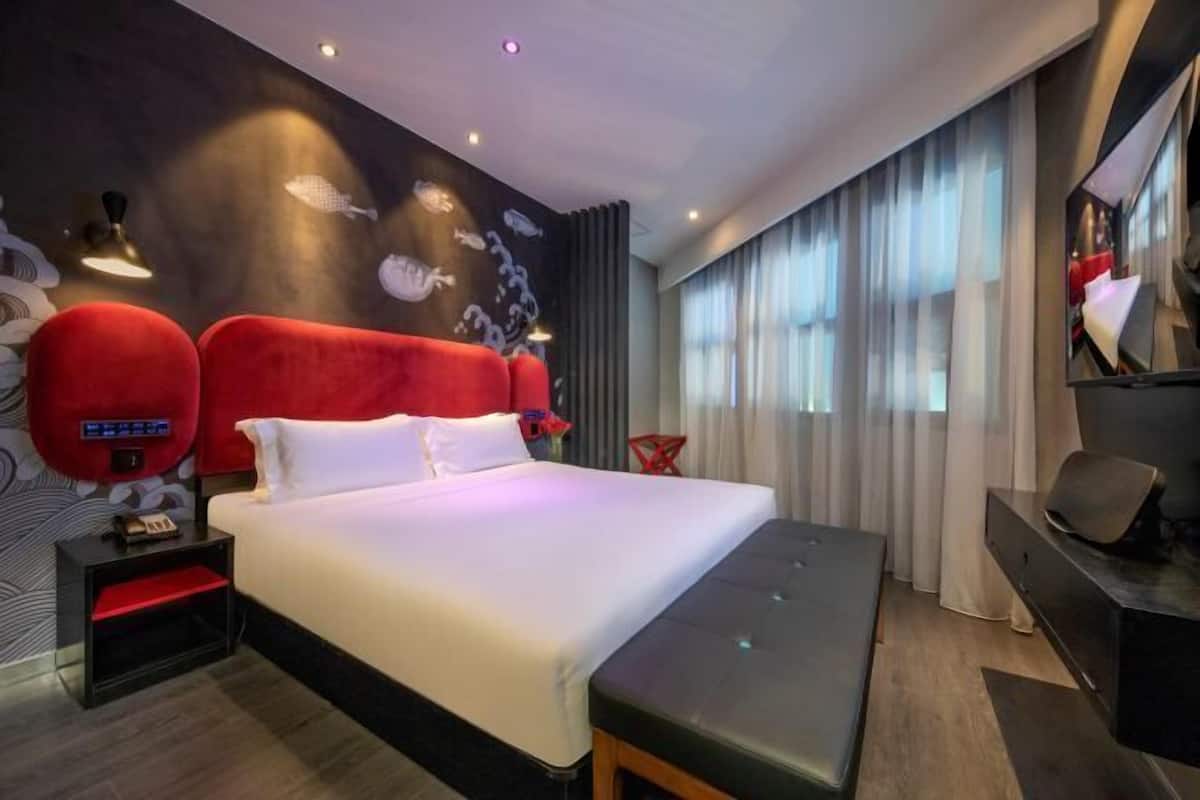 Minibar, escritorio, cortinas blackout y tabla de planchar con plancha