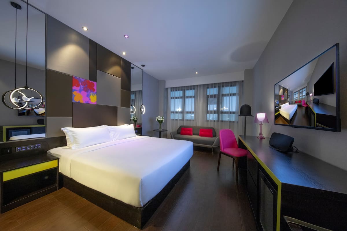 Minibar, escritorio, cortinas blackout y tabla de planchar con plancha
