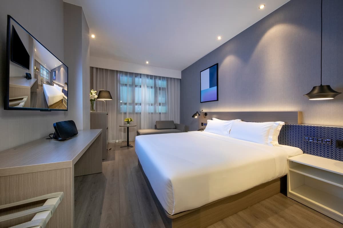 Minibar, escritorio, cortinas blackout y tabla de planchar con plancha