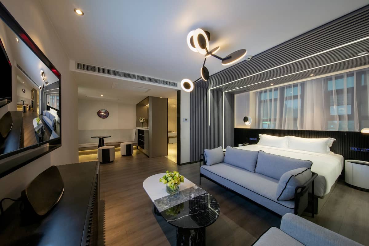 Minibar, escritorio, cortinas blackout y tabla de planchar con plancha
