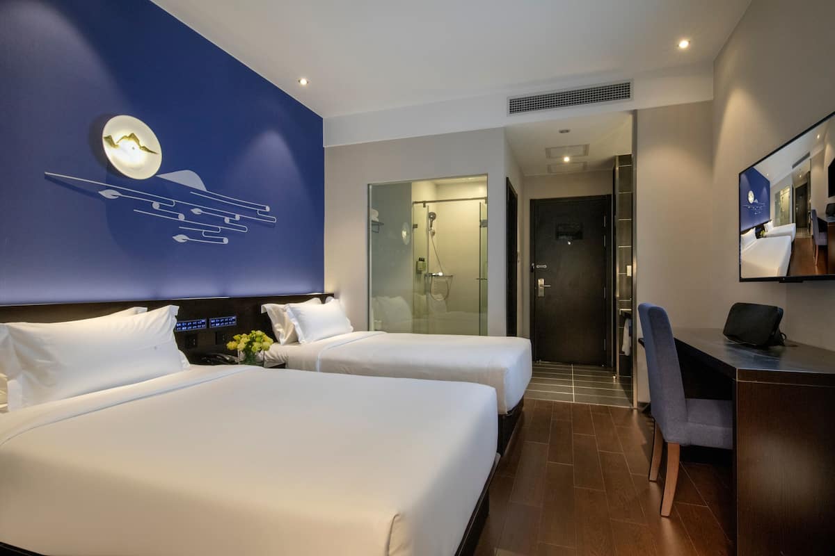 Minibar, escritorio, cortinas blackout y tabla de planchar con plancha