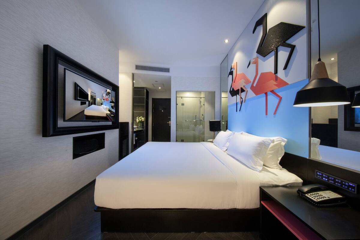 Minibar, escritorio, cortinas blackout y tabla de planchar con plancha