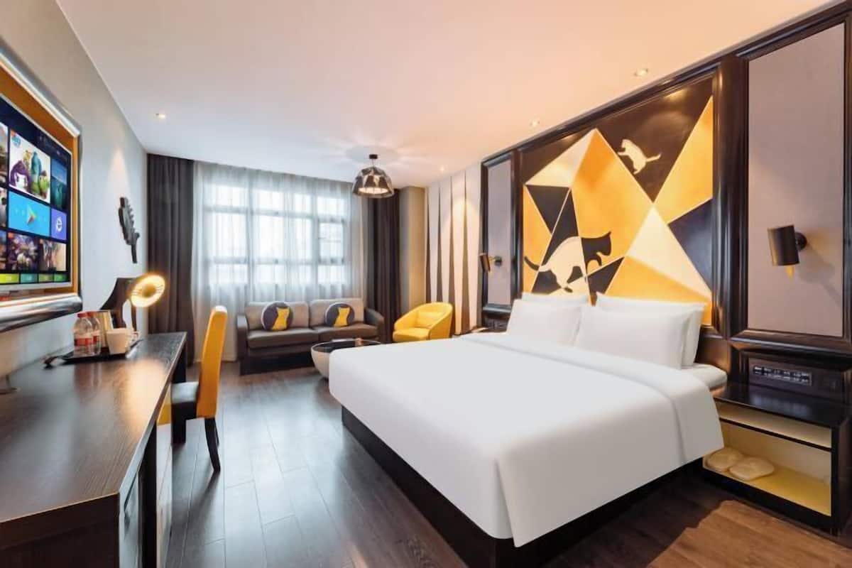 Minibar, escritorio, cortinas blackout y tabla de planchar con plancha