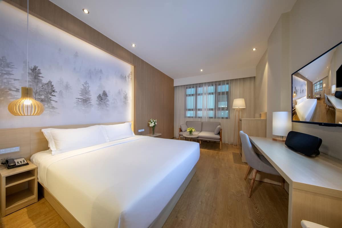 Minibar, escritorio, cortinas blackout y tabla de planchar con plancha
