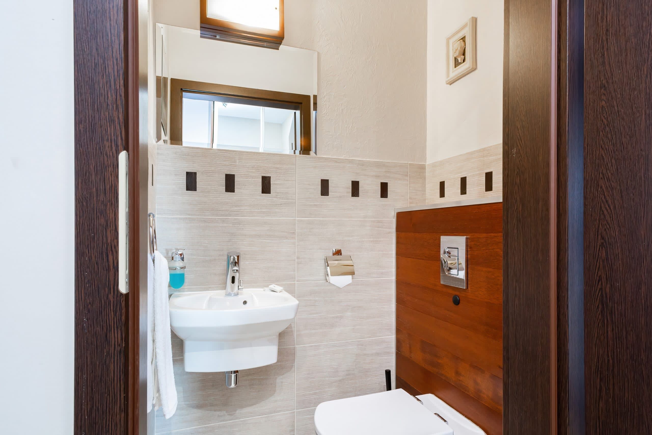 Une salle de bain moderne avec un lavabo, un miroir et des toilettes.