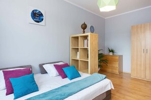 Een slaapkamer met een bed, een houten garderobe, een boekenkast en een kunstwerk aan de muur.