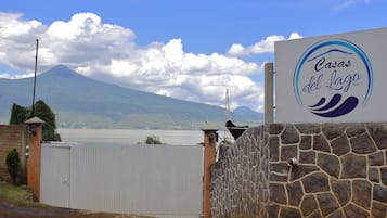 A sign for Casas del Lago Club with a view of a mountain and lake.