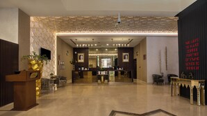A hotel reception area with a modern design, featuring a reception desk, seating area, and a decorative wall with a pattern. - Swiss-Belinn Doha (Doha)