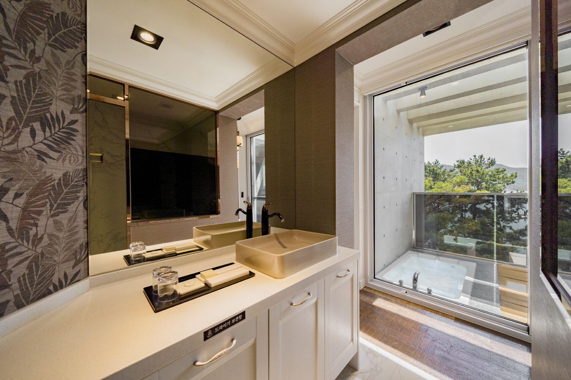 A modern bathroom with a large mirror, two sinks, and a view of a balcony.
