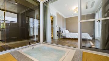 A modern bathroom with a large bathtub, a glass shower enclosure, and a visible toilet.