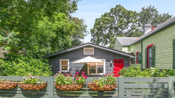 A house with a grey exterior, a red door, and a white umbrella in front. - Quiet and safe Uptown house steps from Audubon Zoo and shopping on Magazine (New Orleans)