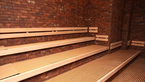 Un conjunto de bancos de madera frente a una pared de ladrillo en un espacio público.
