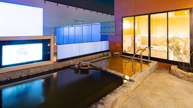 Un área de spa con un jacuzzi, paredes de piedra y un mostrador de recepción.
