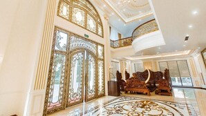 Un lobby lujoso con puertas decorativas, una gran araña y una zona de estar confortable.