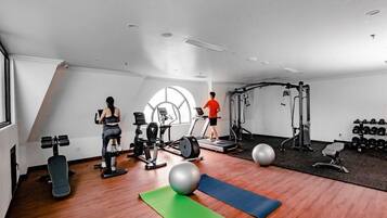 Una palestra con attrezzature per esercizi, tapis roulant e cyclette.