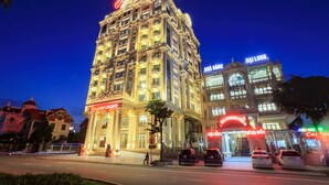 Un hotel de varios pisos con letreros iluminados, incluyendo “Dragon Legend” y “Da Long”.