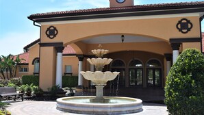 Un bâtiment doté d’une tour horlogée, d’une fontaine et d’un banc.