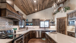 A modern kitchen with wooden cabinets, a stainless steel dishwasher, and a large island.