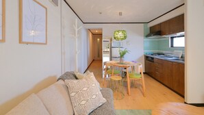 Un salon moderne comprenant un canapé, une table à manger avec des chaises et un coin cuisine avec des placards et une cuisinière.