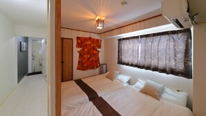 Une chambre d’hôtel avec un grand lit, un climatiseur fixé au mur et une fenêtre avec des rideaux.