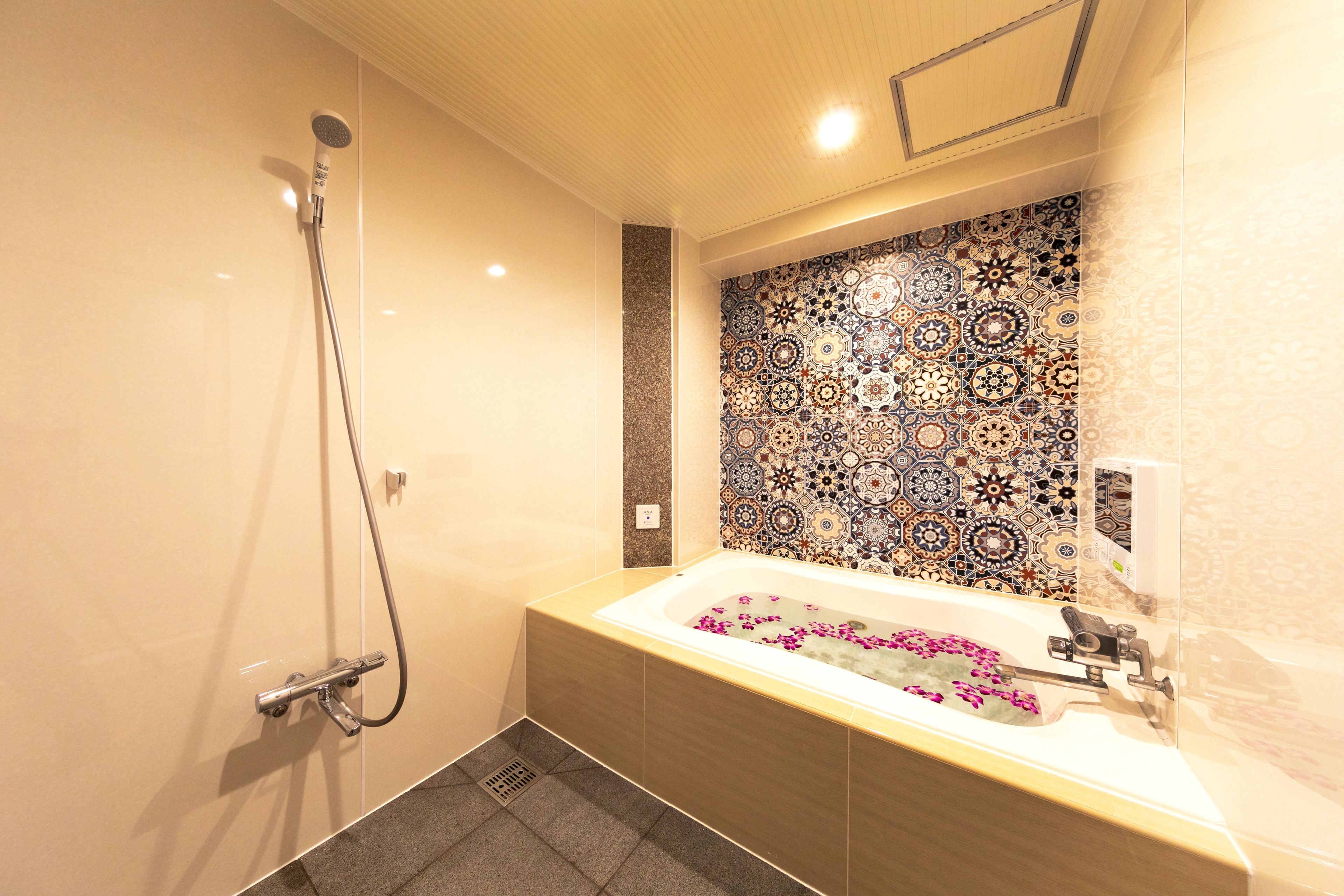 Um banheiro moderno com uma banheira de pedestal, chuveiro e painel de azulejos decorativos.