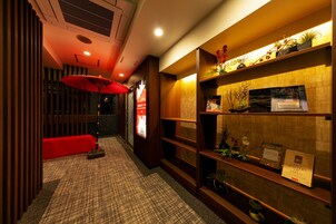 Un pasillo con un banco rojo, una chimenea decorativa y una estantería con libros y plantas.