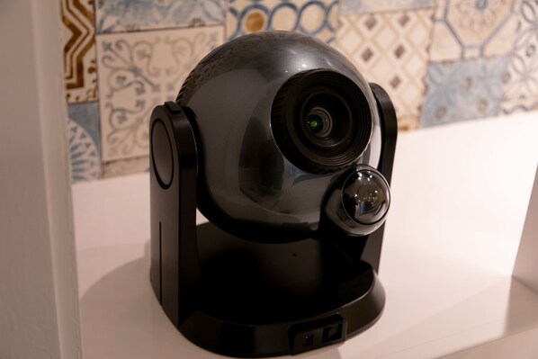 A surveillance camera with a dome design, positioned on a white surface against a tiled wall. - Hotel Eldia Japanese Modern - Adults only (Gyoda)