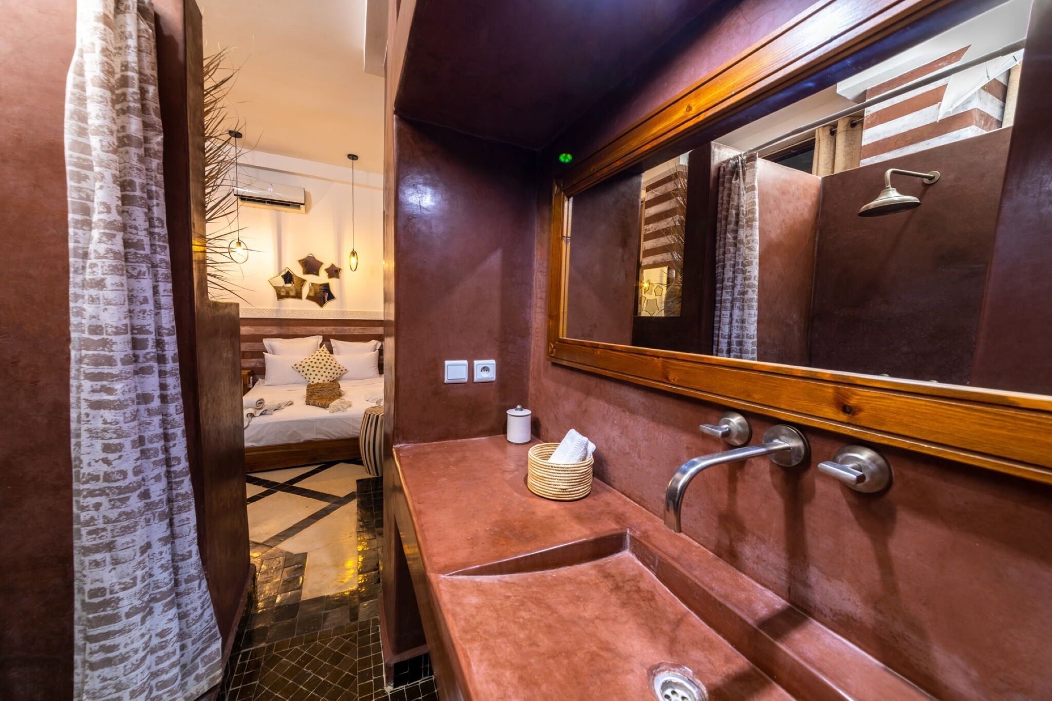 Un bagno con un grande specchio, un lavandino e una zona doccia.