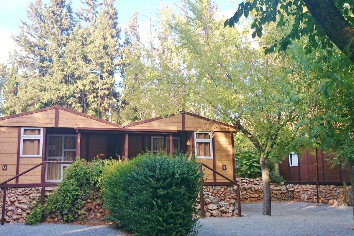 A rustic lodge with a stone foundation, wooden exterior, and multiple windows.