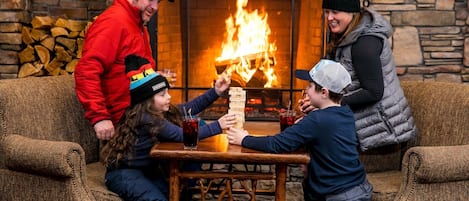 Een gezin speelt Jenga voor een open haard.