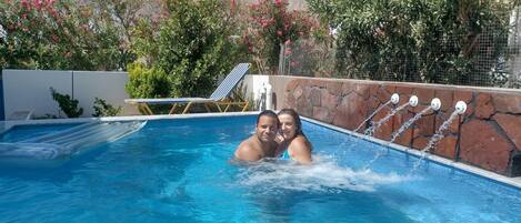 Una piscina al aire libre de temporada, sombrillas, tumbonas