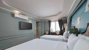A hotel room with two beds, a flat-screen TV, an air conditioning unit, a window with curtains, and a wall mural. - Madelise Central Hotel & Travel (Hanoi)