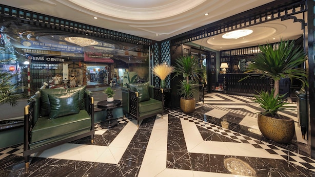 A lobby with a checkered floor, green seating, and potted plants. - Madelise Central Hotel & Travel (Hanoi)
