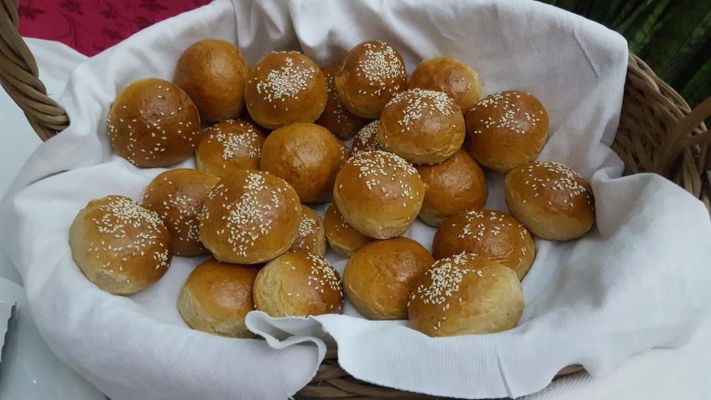 Un panier rempli de petits pains aux graines de sésame.