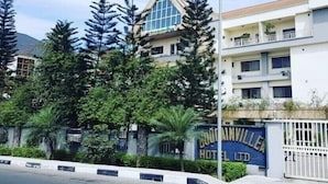 A hotel with a prominent entrance gate, a clear sky, and surrounding greenery. - Bougainvillea Hotel (Port Harcourt)