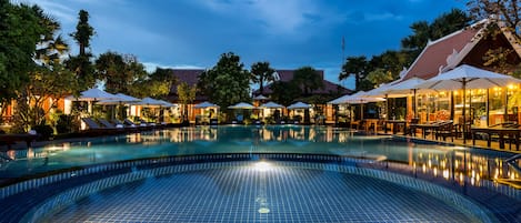 Una piscina al aire libre, camas de piscina gratis, sombrillas